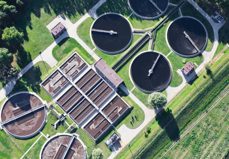 Aerial view of water tanks on a green field.