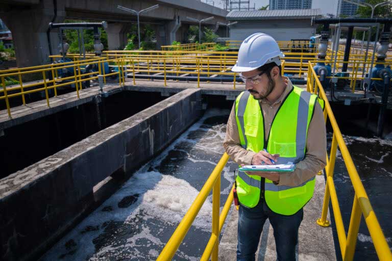 A facility worker checking a large water tank.